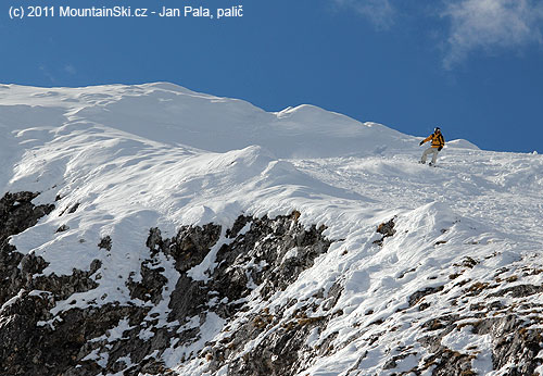 Snowboardista nad jedním z mnoha skalnatých srázů