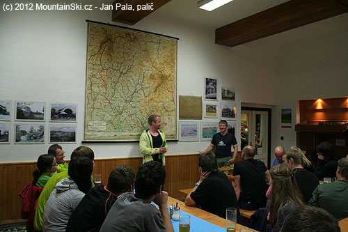 Představení Hillebergu, Daniel mluví před nástěnou mapou ze třicátých let dvacátého století, volně překládá Ondřej