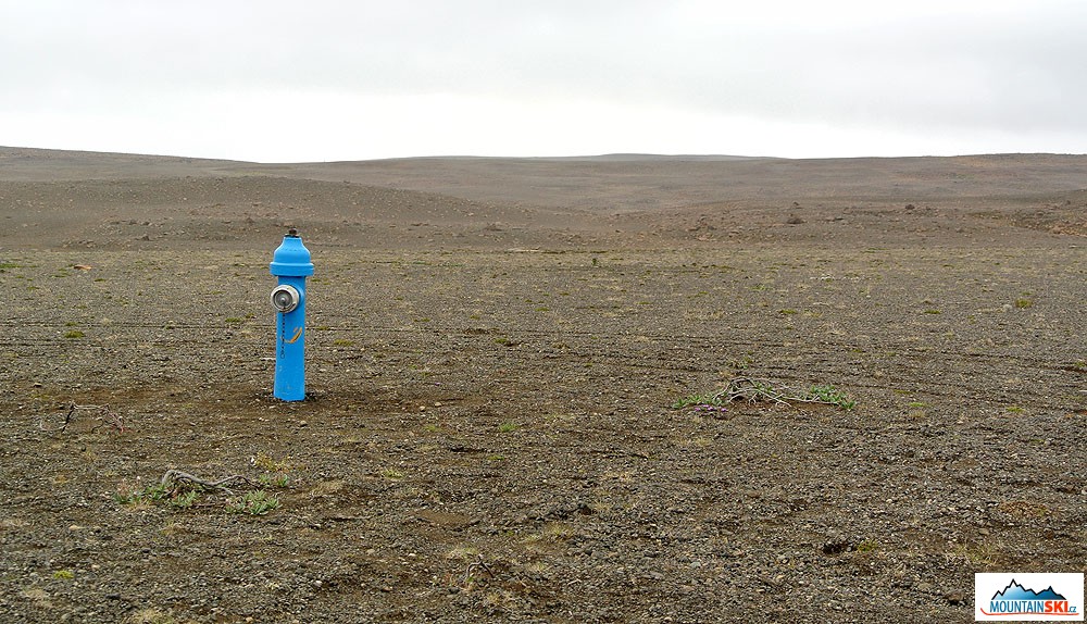 Nepochopitelně umístěný hydrant uprostřed štěrkové pouště